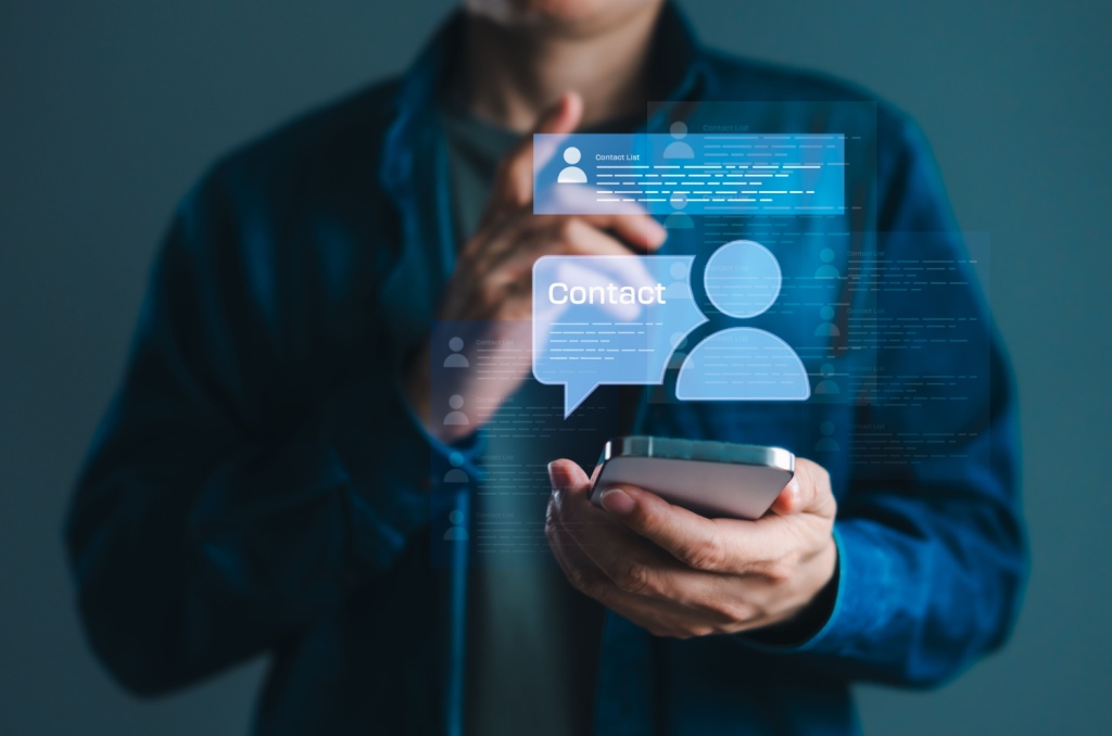 Person using a smartphone with digital contact icons displayed, illustrating how to organize and access an emergency contact list on a mobile device.