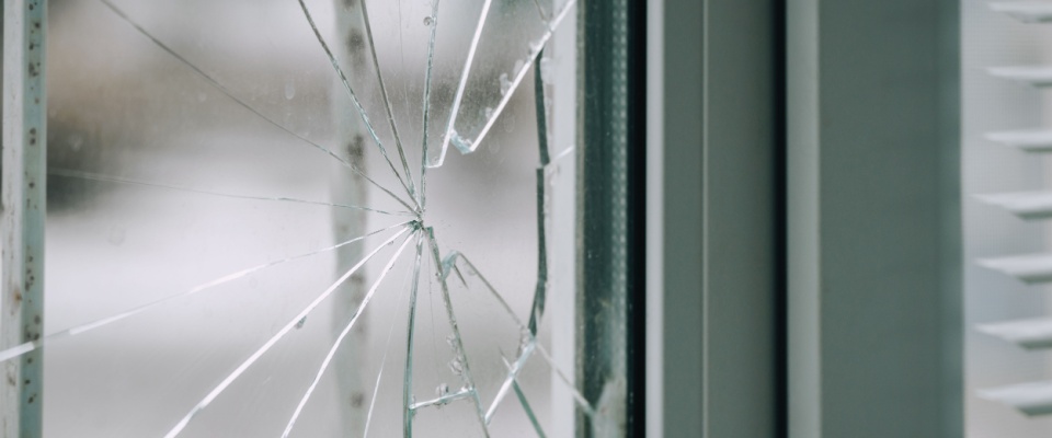 Cracked window glass close-up, showing an example of home repairs renters insurance covers property damage for after unexpected incidents.