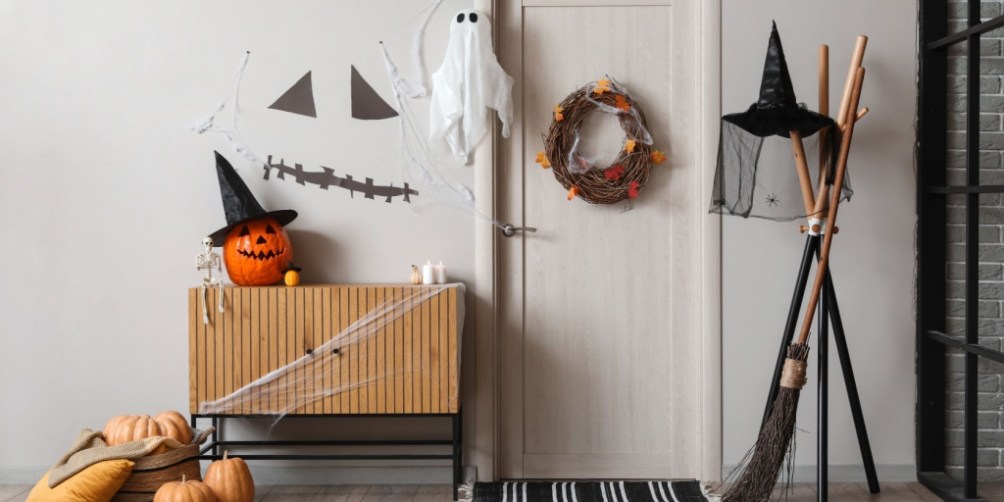 Front entryway decorated with pumpkins, witch hats, and cobwebs, showing festive yet mindful Halloween safety home decorating tips.