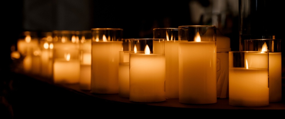 Multiple LED candles glowing in the dark, demonstrating safe decoration ideas to prevent fire hazards and improve Halloween safety.