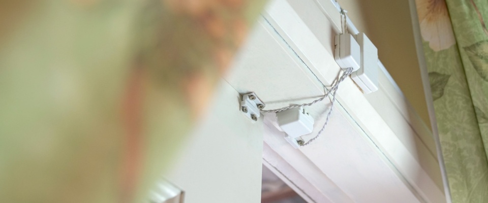 Close-up of window sensors mounted on a door frame, demonstrating safety gadgets that help detect break-ins or unauthorized entry.