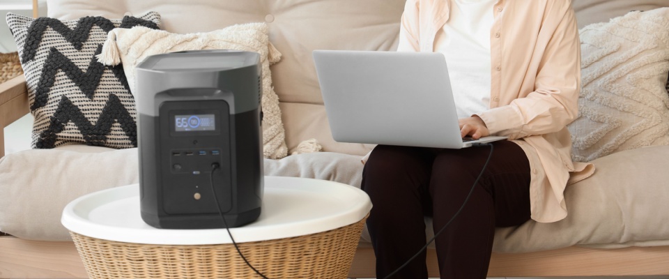 Portable power station running a laptop in a living room, demonstrating safe and reliable backup power for your apartment.