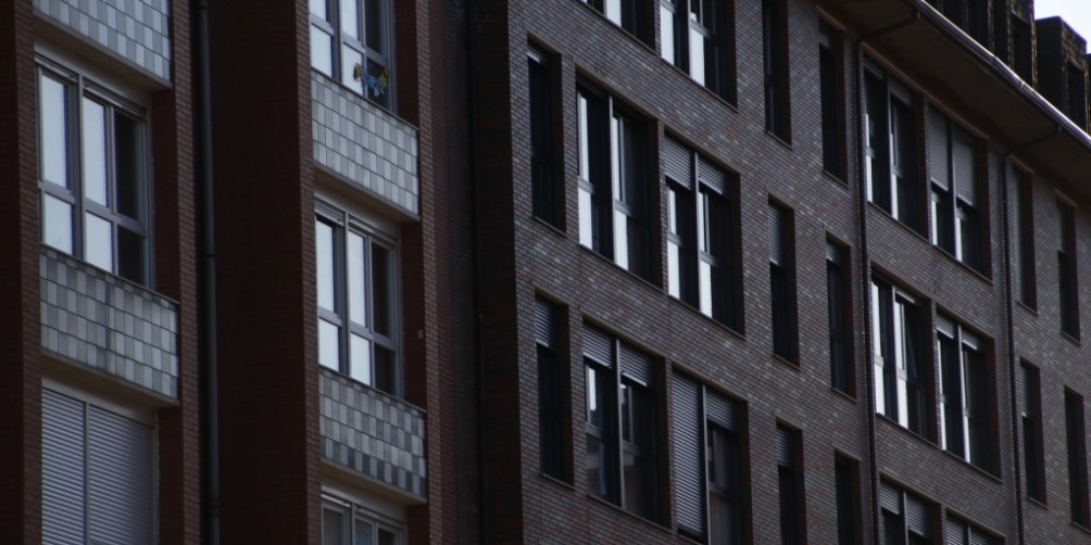 Exterior of a multi-unit apartment building at dusk, showing how residents may be affected during a neighborhood rolling blackout.